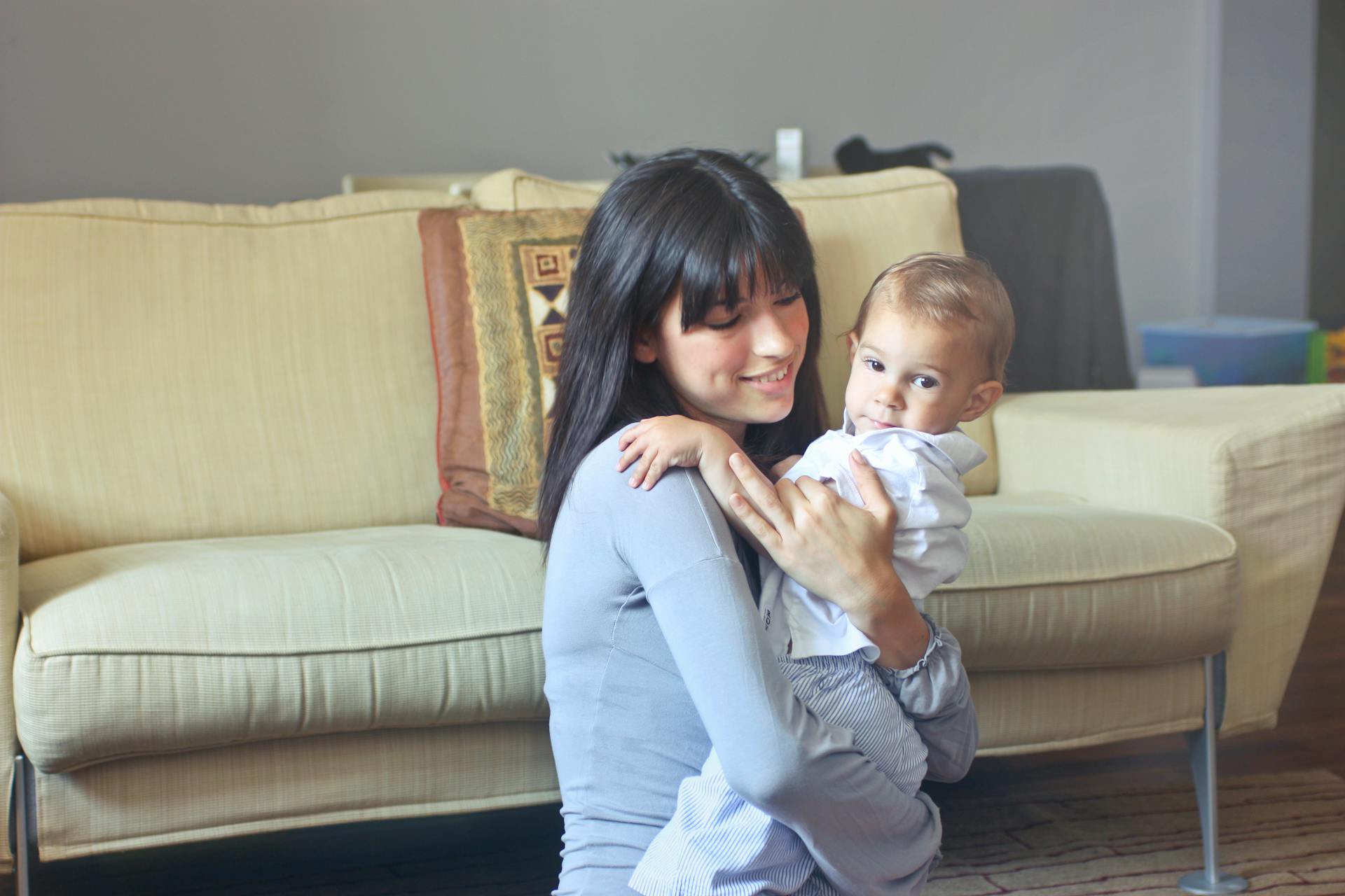 A woman holding a child in her arms | Source: Pexels