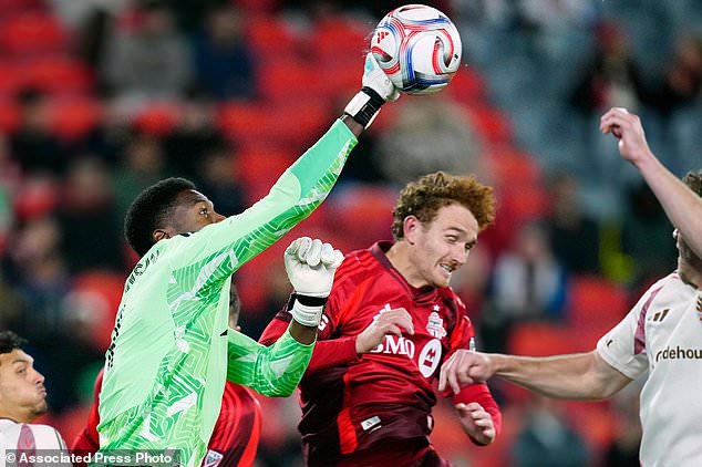 D.C. United goalkeeper Sean Johnson, left, clears the ball away from Toronto FC forward Josh Sargent during the second half of an MLS soccer game in Toronto on Wednesday, Oct. 28, 2026. (Frank Gunn/The Canadian Press via AP)
