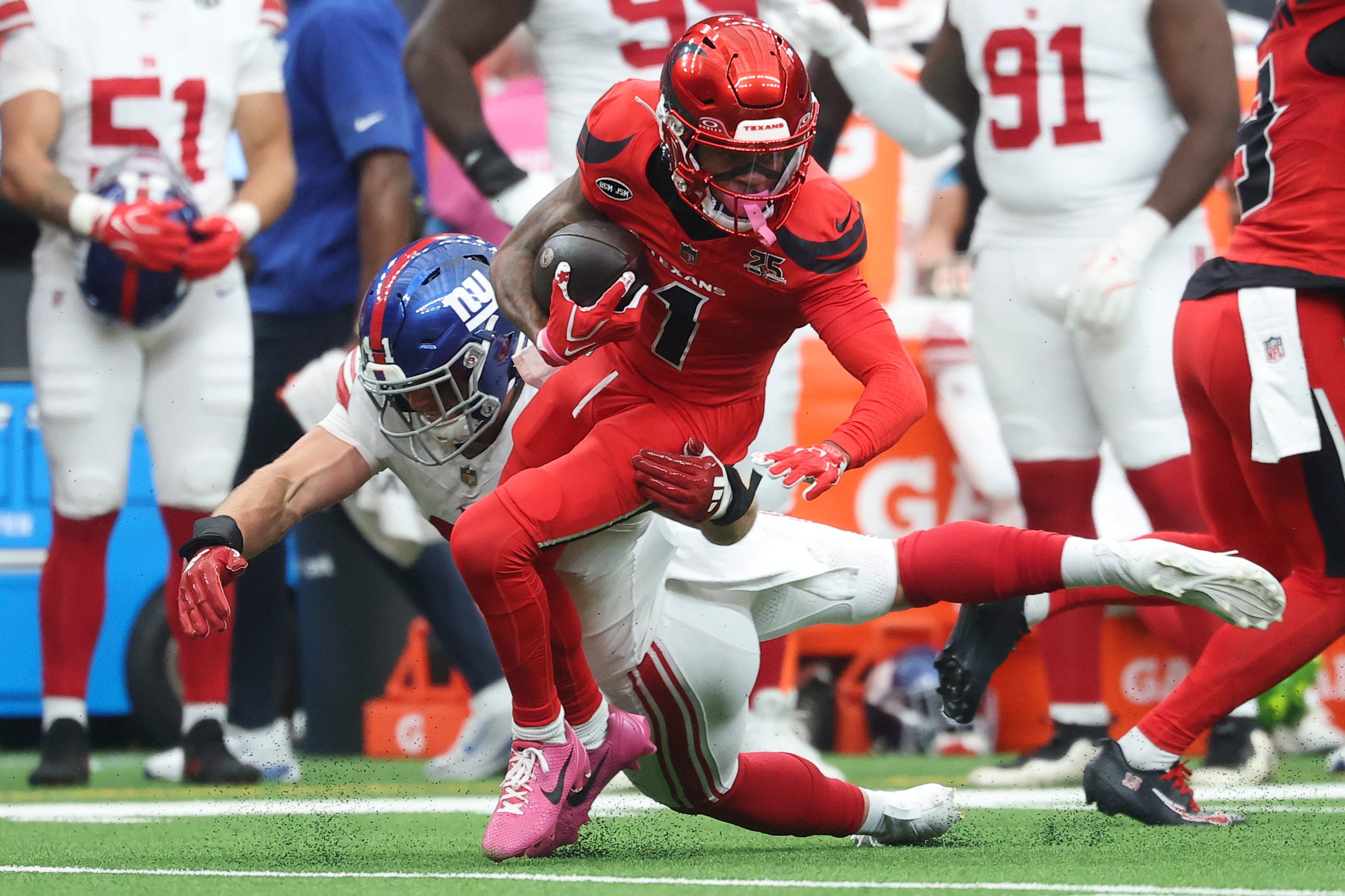 Oct 25, 2026; Houston, Texas, USA;  Houston Texans wide receiver Tank Dell (1) runs with the ball as New York Giants linebacker Micah McFadden (41) defends during the third quarter at Reliant Stadium.  Mandatory Credit: Troy Taormina-Imagn Images