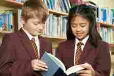 Pupils wearing uniform in library.