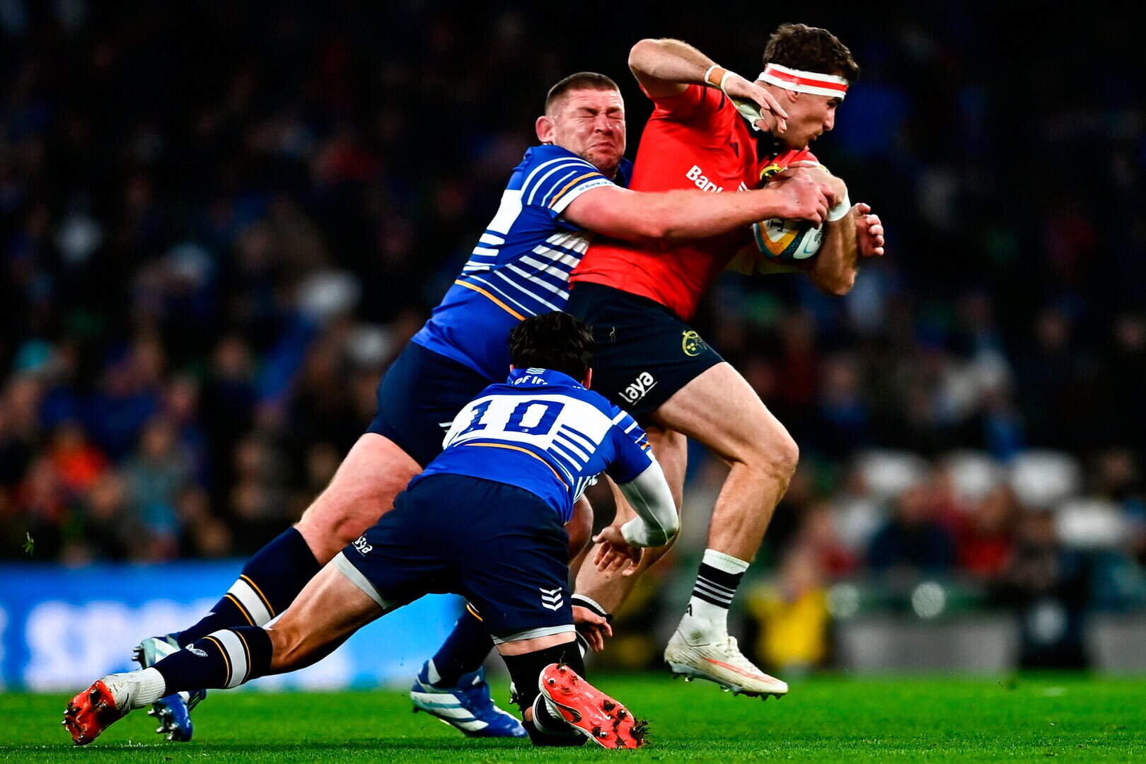 Munster’s Shane Daly is tackled by Tadhg Furlong, left, and Joey Carbery of Leinster during the URC match at the Aviva Stadium in Dublin