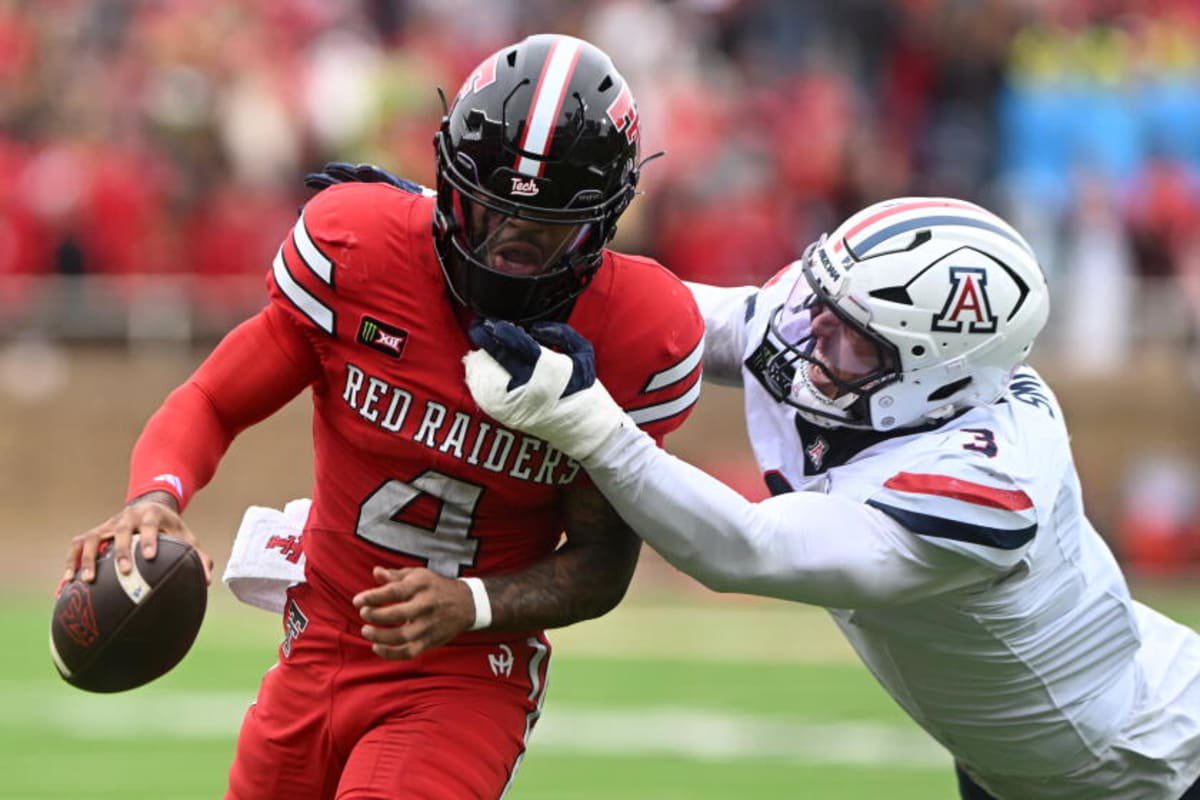 Texas Tech quarterback Tommy Castellanos, left, tries to shed the tackle attempt Arizona defensive lineman Tre Smith on a run